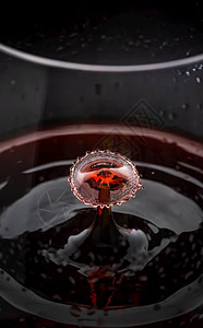 红酒滴洒在玻璃里摘要背景红酒滴洒在玻璃里紧关上图片