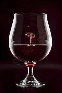 红酒滴洒在玻璃里摘要背景红酒滴洒在玻璃里紧关上图片