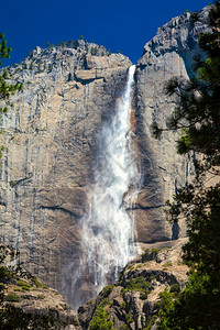 在明亮蓝天下的上Yosemite瀑布图片