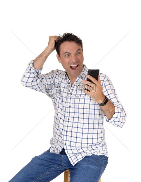 一个年轻人拿着他的手机看非常惊讶他手机上的东西抓头