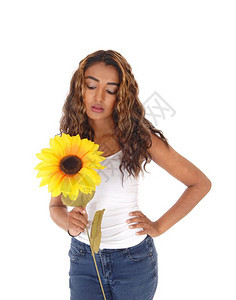 一个笑的少女长卷发黑看着她手里拿的向日葵与白种背景隔绝图片