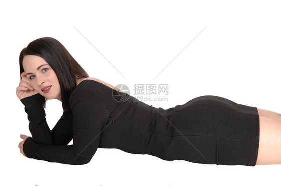 一个美丽的年轻女孩躺在黑色衣服和头发上躺在她的肚子上地板她的漂亮身材图片