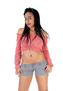 美丽的年轻女子站立灰短裤和粉红色毛衣长的黑头发白背景隔离图片