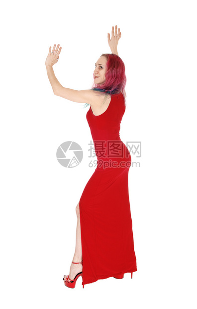 一位美的年轻女子穿着长的红裙子穿着色高厚的礼服的头发举起双手与白种背景隔绝图片