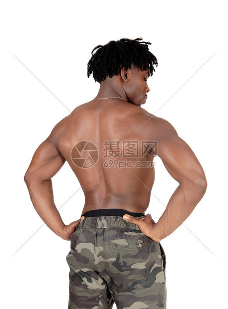 一个年轻英俊的健美运动员站在后背的穿着迷彩短裤向下看与白背景隔绝图片