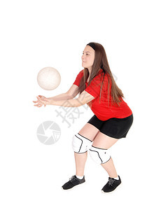 一个穿制服的年轻少女穿着制服玩排球试图用手抓住球与白种背景隔绝图片
