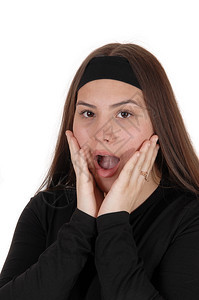 一个穿着黑色毛衣的年轻少女惊讶地用张开的嘴手握着脸部张开嘴为白背景而孤立图片