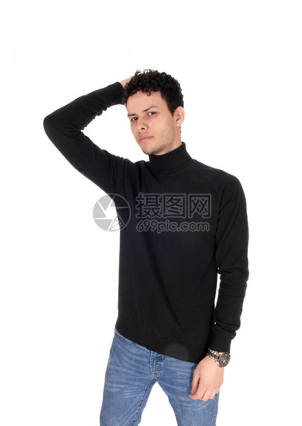 站在工作室的一个瘦年轻男子站在工作室一只手在头上穿着一件毛衣看镜头与白色背景隔绝图片