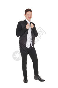 一个快乐的年轻男孩站着笑是一个黑色夹克和裤子黑色裙长蹄孤立的白色背景图片