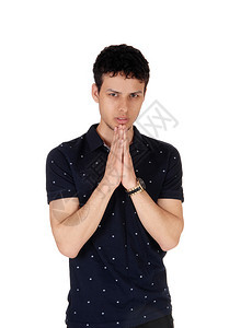 一个年轻帅气的人近形象站在工作室的腰部上双手折叠祈祷与白种背景隔绝图片