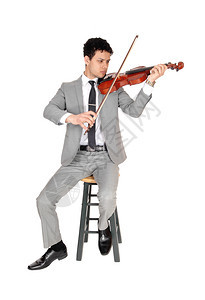一个穿着灰色西装的英俊年轻男子玩小提琴看着集中的严肃与白背景隔离图片