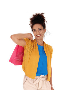 一个美丽的笑着容多种族妇女站在她的购物袋站在她的肩膀上穿着黄色毛衣图片