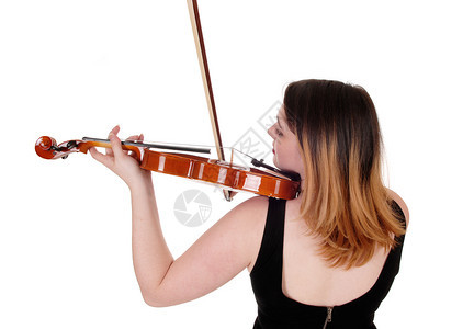 一个站在后面的年轻女人站在一个近距离的画面里用她金发拉着小提琴背景图片