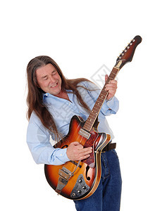 一个快乐的音家用长的黑发弹吉他唱歌与白种背景隔绝图片