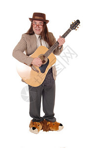 一个穿花鞋的中年土著男子站在夹克帽里弹吉他和图片