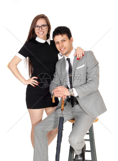 一对微笑的年轻夫妇坐着的男子站在工作室的女士站在工作室的肖像画图片