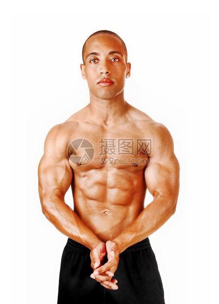 一个年轻男子站在工作室双手折叠展示他伟大的体形和肌肉与白种背景隔绝图片