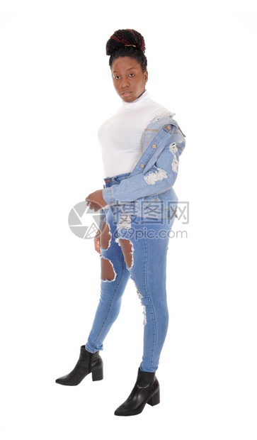 一个年轻的非裔美国妇女穿着破牛仔裤外套站在肩上白顶图片