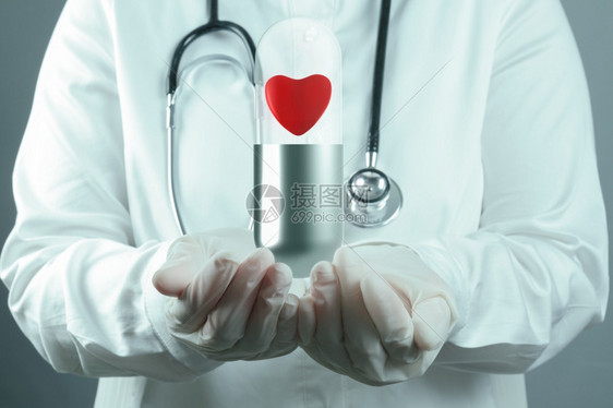 医生科学家将红心药丸作为医学概念在胶囊内展示图片