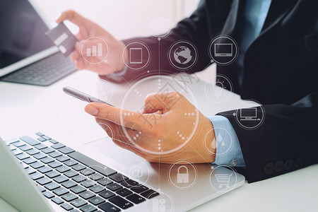 商人在网上购买信用卡在现代服务台用移动电话和膝上型计算机VR图标图片