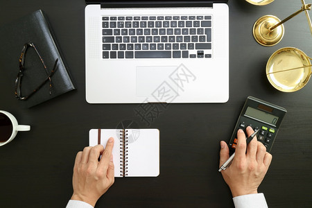 使用计算器和笔记本电脑以及现代办公室文件处理账户的商人或律师会计图片