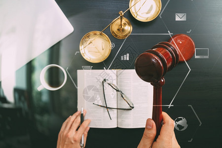 正义和法律概念男法官手拿木槌铜秤和电脑在法庭上的俯视图打开深色木桌上的圣经书用Vr图图片