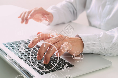 在现代办公室的白色桌上用VR图标用笔记本电脑打键盘图片