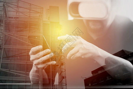商人在现代办公室佩戴虚拟现实护目镜手持智能机用VR头盔与伦敦市接触图片