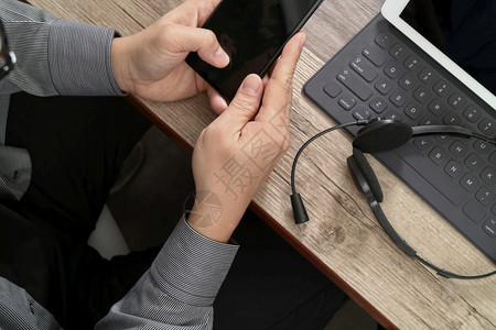 使用数字平板电脑对接键盘智能电话概念通信支持呼叫中心和木桌客户服务台图片