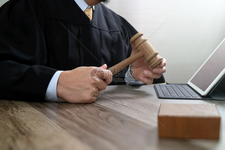 法官在庭上使用手镯与数字平板电脑对接键盘在木板上工作图片