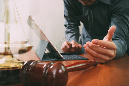 手架上的在职男律师用智能电话数字平板脑和木上的黄铜比例计数机和字平板电脑工作图片