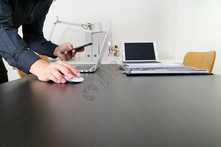 在现代办公室使用装有顶式电脑和数字平板的鼠机和智能电话的商人或设计师图片