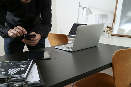 使用智能电话的商家或设计师使用电脑和数字平板以及现代办公室的桌上文件图片