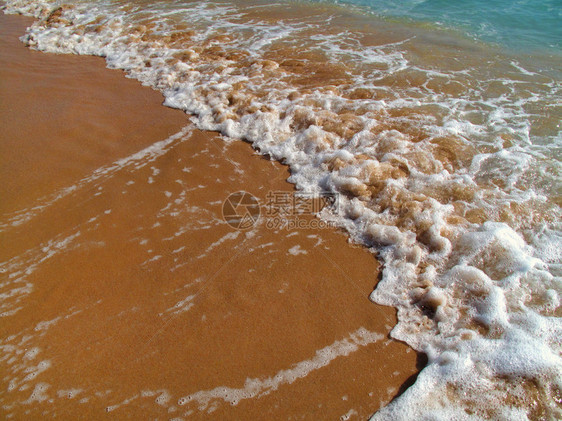 海浪沙滩上有白泡沫自然背景图片