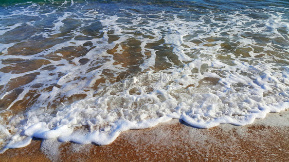 沿海沙砂中含有白泡沫的海水天然封闭背景图片