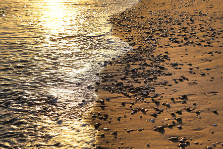 海滨在阳光照下沙滩上有石子自然近身背景图片