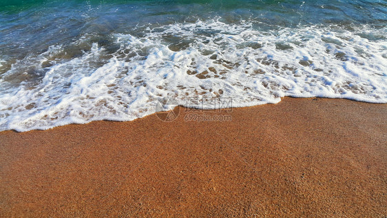沿海沙砂中含有白泡沫的海水天然封闭背景图片