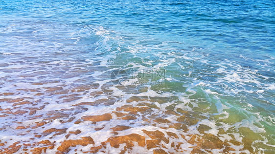 沿海沙砂中含有白泡沫的海水天然封闭背景图片