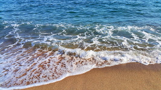 沿海沙砂中含有白泡沫的海水天然封闭背景图片