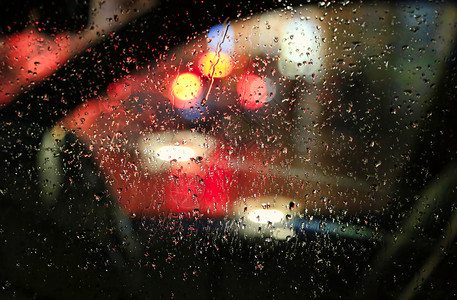 夜晚大城市的灯光穿过车玻璃满是雨滴图片