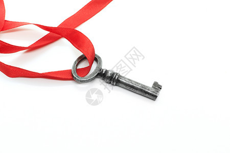 白色背景上的红丝带被隔离的银金钥匙图片