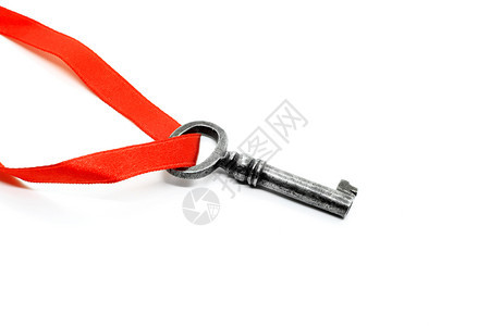 白色背景上的红丝带被隔离的银金钥匙图片