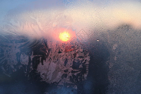 令人惊叹的冰雪模式和水滴在冰冻的窗上在阳光明媚的冬天清晨关闭自然质地图片