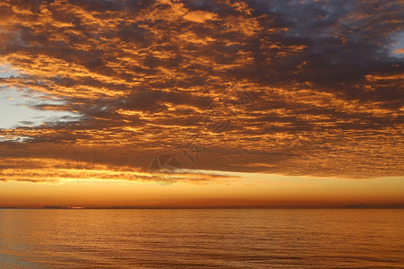 清晨在海中日出时阳光明亮天空中云彩图片