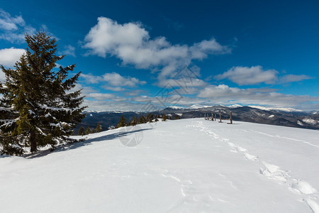 山地农村雪覆盖的道路和足迹图片