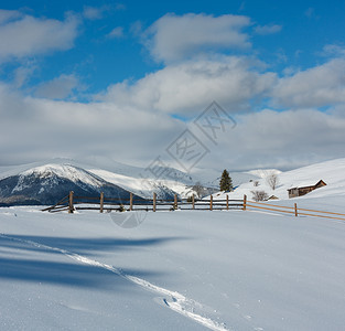 山地农村雪覆盖的道路和足迹图片