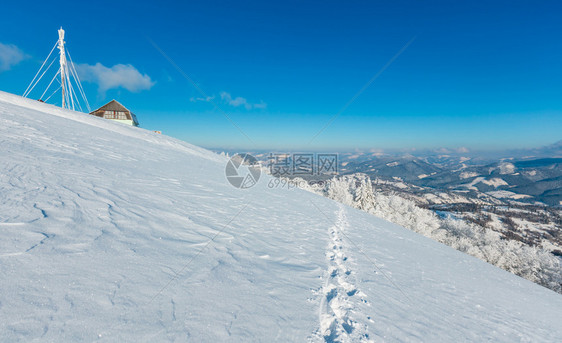 美丽的冬季红霜树通讯塔和人行道穿过蓝天空背景的山坡上雪田喀尔巴阡山乌克兰图片