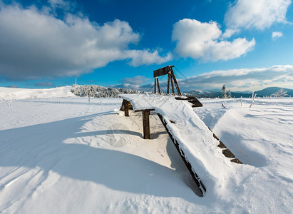 上午清晨冬季平静的山地景观有木制平台斜坡上的雪梯和山顶远处的通讯塔乌克兰喀尔巴阡山图片