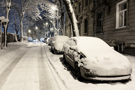 乌克兰利沃夫市中心美丽的黄昏冬季城市景观汽车被雪覆盖了图片