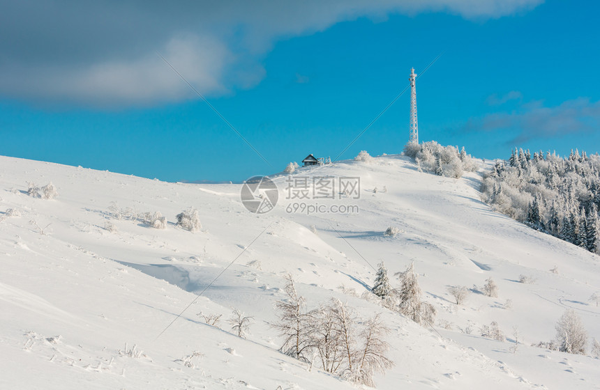 美丽的冬季霜树通讯塔和山顶上蓝色云雾天空背景的雪地滑喀尔巴阡山乌克兰图片